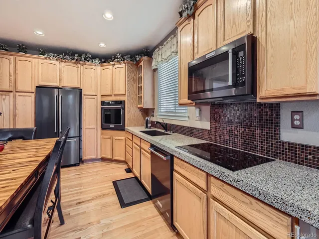 a kitchen with stainless steel appliances granite countertop a stove a sink and a microwave