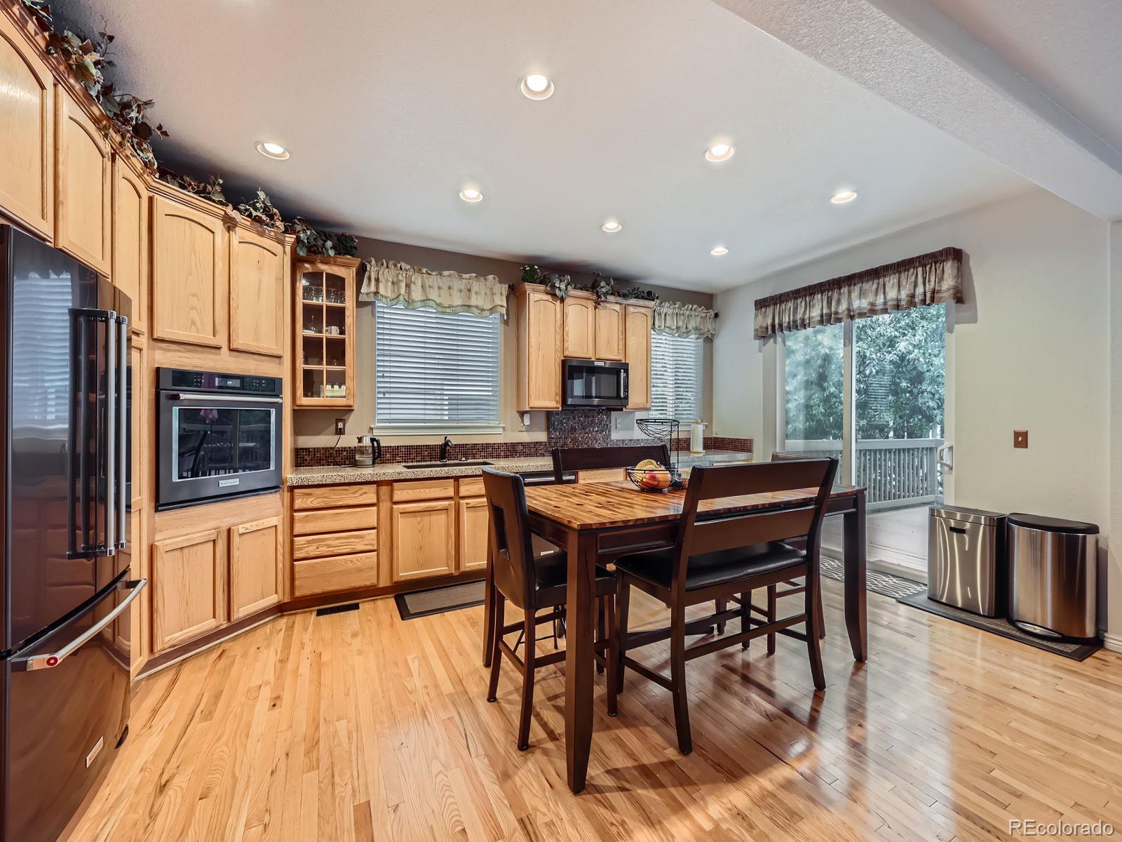 3000 Fox Sedge Lane Highlands Ranch, CO 80126 - Photo 33 of 33 a kitchen with stainless steel appliances granite countertop a stove a refrigerator a kitchen island a table and chairs in it