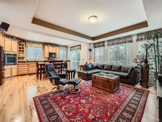 a living room with furniture large window and wooden floor