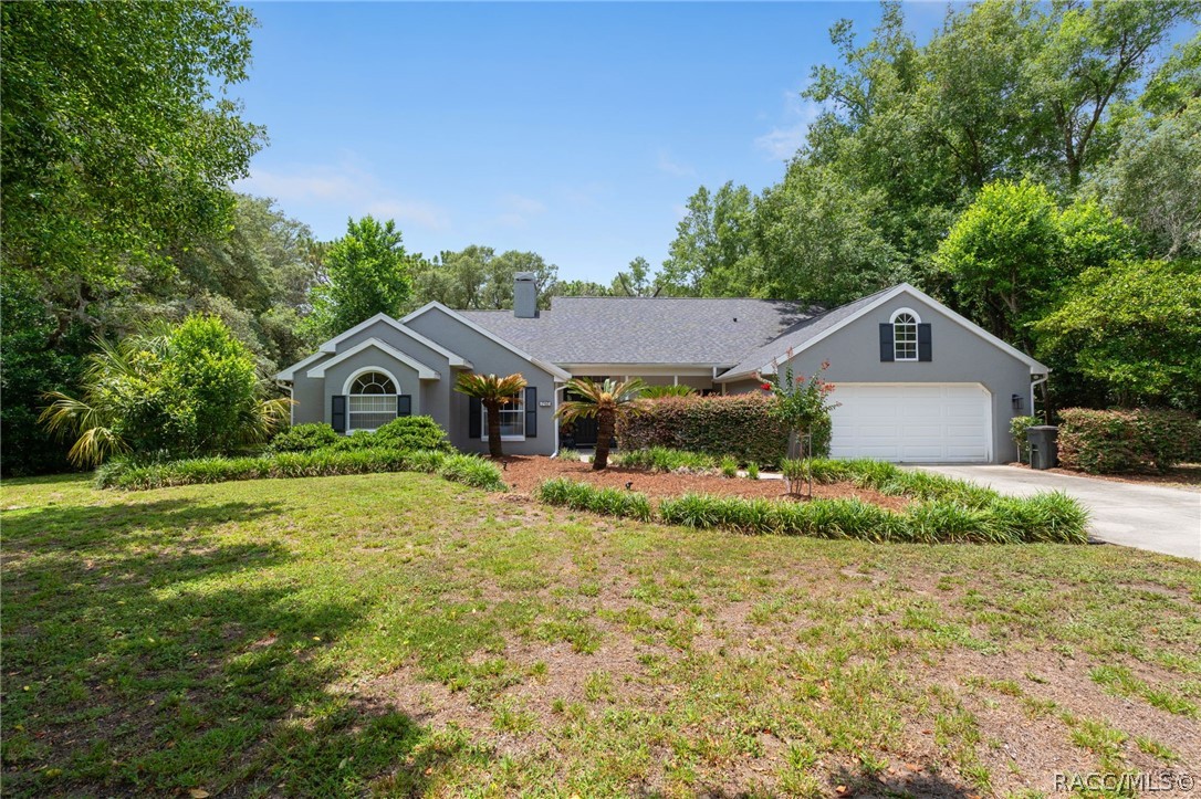 2460 West Pine Ridge Boulevard Beverly Hills, FL 34465 - Photo 1 of 47 a view of a house with a yard and garage