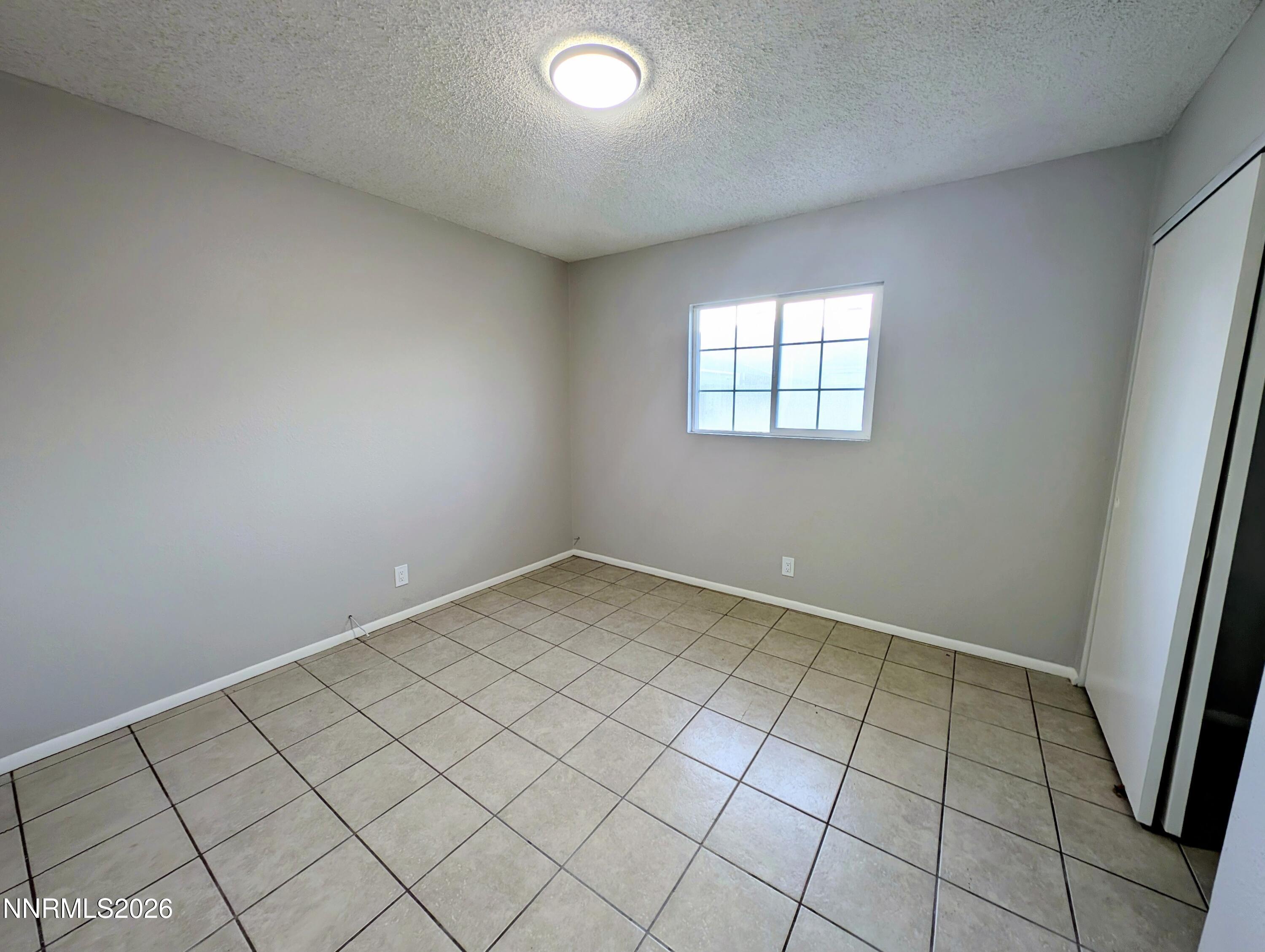 367 Connelly Street Hawthorne, NV 89415 - Photo 21 of 32 an empty room with white walls and tiles