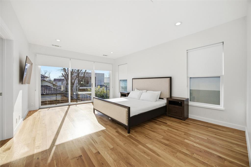 5326 Manett Street Dallas, TX 75206 - Photo 15 of 36 a view of a bedroom with a bed and wooden floor