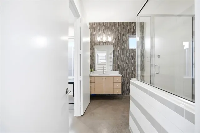 a bathroom with a shower sink and mirror