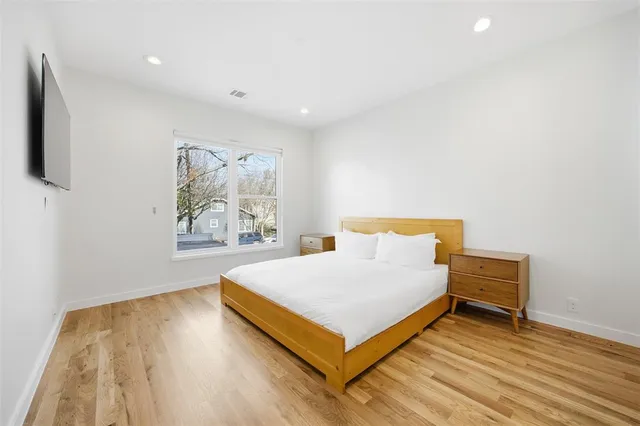 a bedroom with a bed and a potted plant on dresser