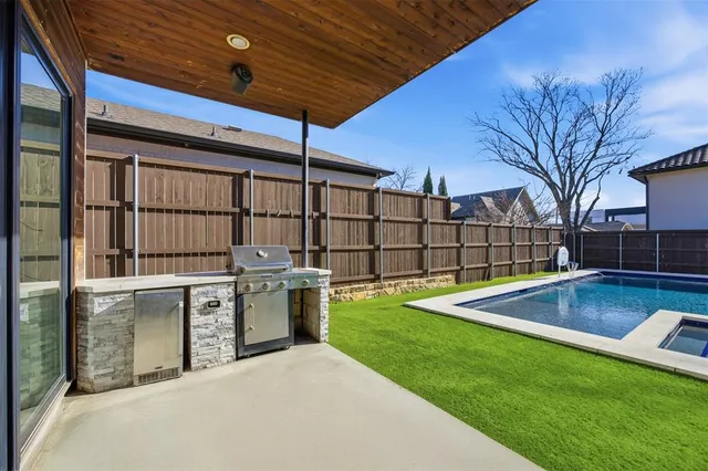 a view of backyard with swimming pool and seating space