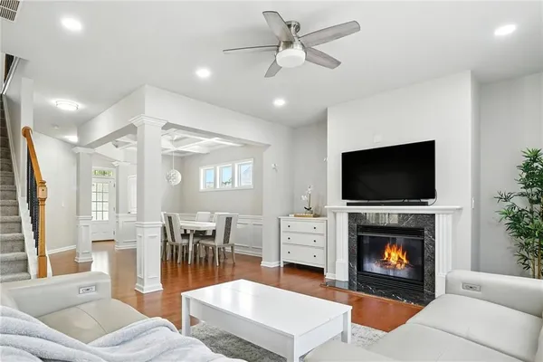a living room with furniture a flat screen tv and a fireplace