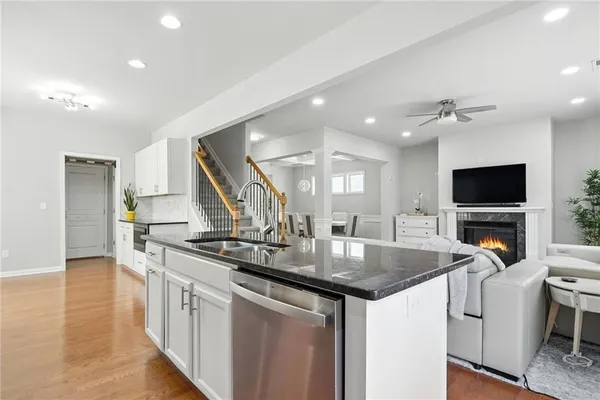 a kitchen that has a sink and a stove with wooden floor