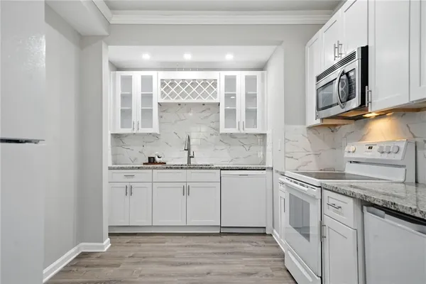 a kitchen with stainless steel appliances granite countertop a sink and a stove top oven