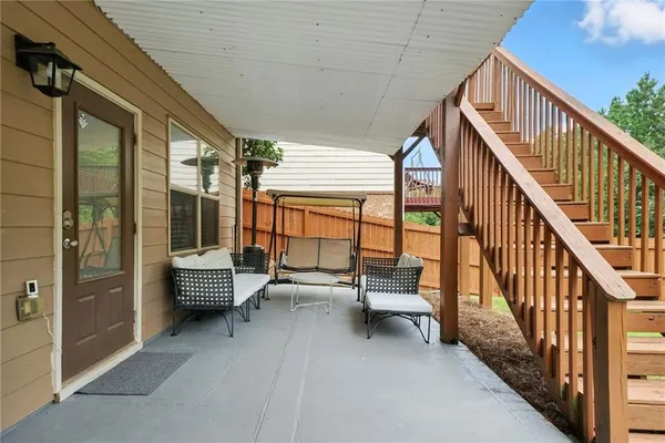 a balcony with chairs and wooden fence