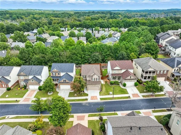 an aerial view of residential houses with outdoor space and trees