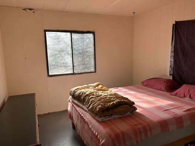 a bed sitting in a bedroom next to a window