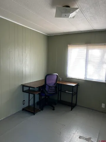 a view of a workspace with furniture and a window