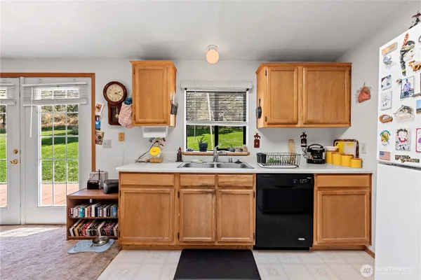 a kitchen with stainless steel appliances granite countertop a refrigerator a stove top oven a sink dishwasher and white cabinets with wooden floor