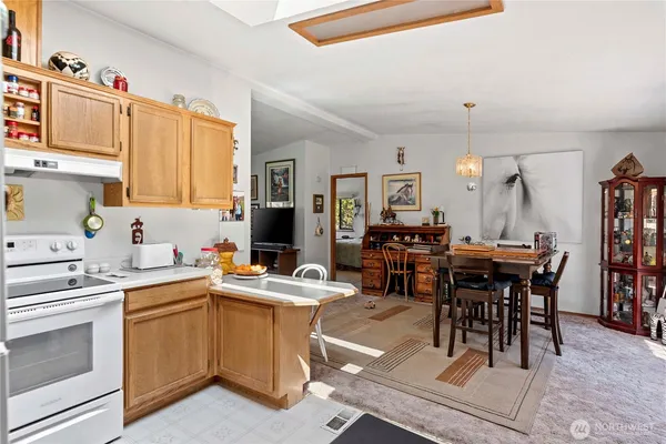 a room with stainless steel appliances kitchen island granite countertop furniture and a chandelier
