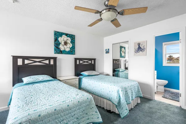 a bedroom with two beds and painting on the wall