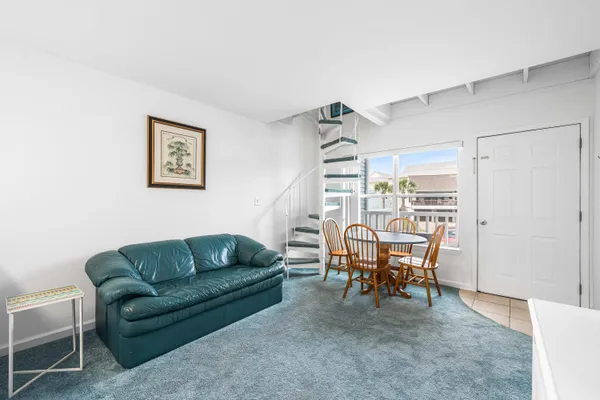 a living room with furniture and a dining table with kitchen view
