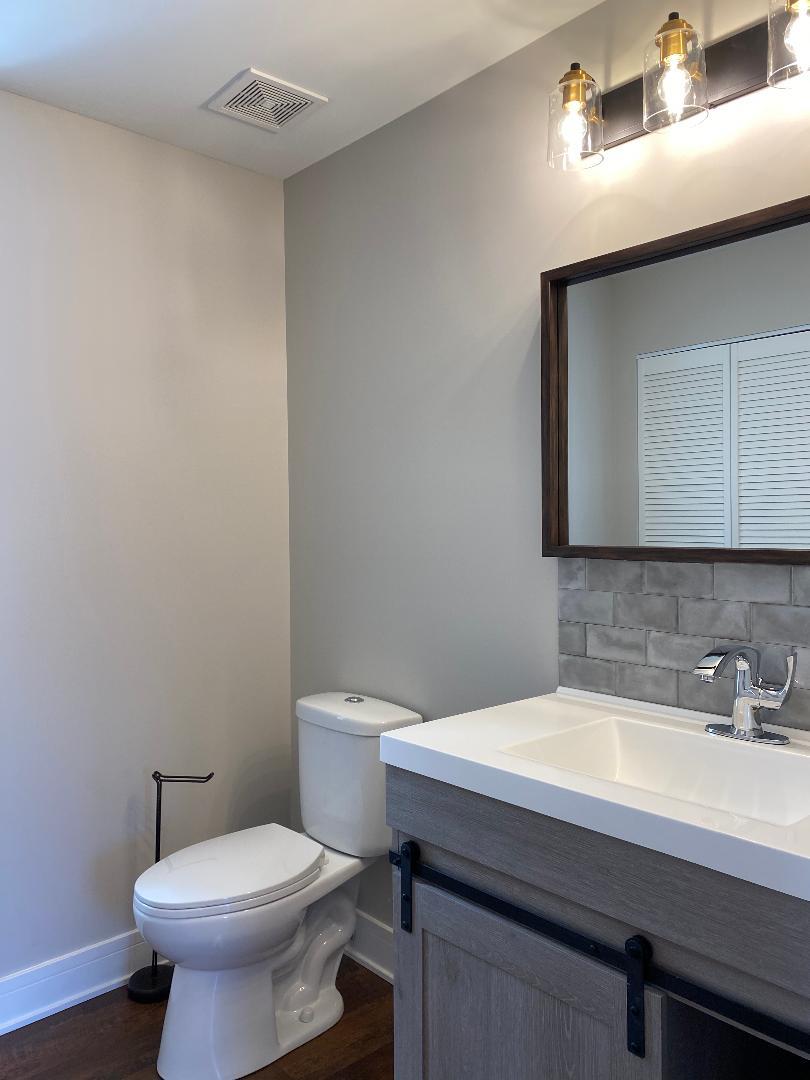 8211 43rd Place Lyons, IL 60534 - Photo 12 of 25 a bathroom with a toilet a sink and mirror