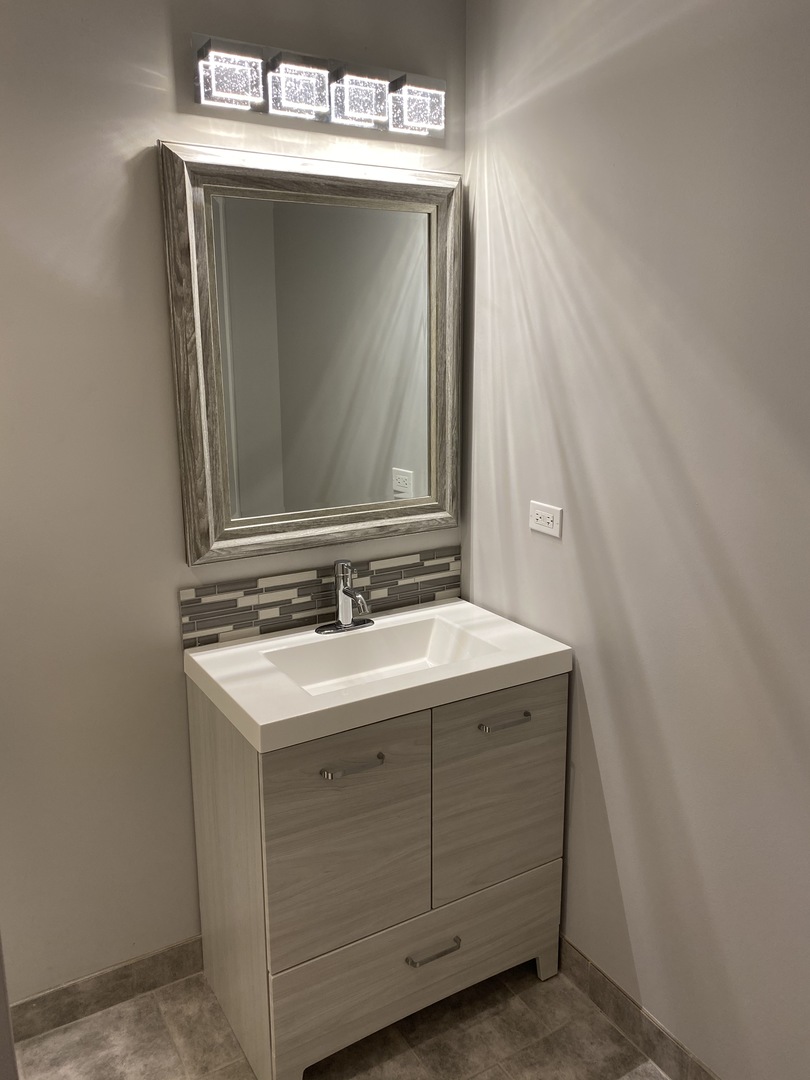8211 43rd Place Lyons, IL 60534 - Photo 16 of 25 a bathroom with a sink and a mirror