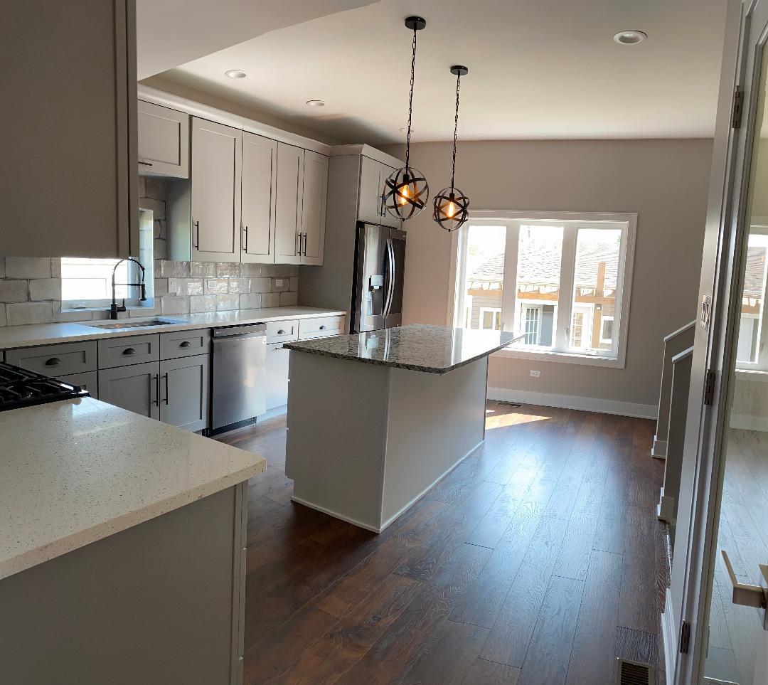 8211 43rd Place Lyons, IL 60534 - Photo 6 of 25 a kitchen with stainless steel appliances granite countertop a refrigerator a sink dishwasher a stove and white countertops with wooden floor
