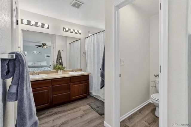 a bathroom with a double vanity sink mirror and toilet