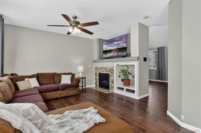 a living room with furniture a fireplace and a flat screen tv