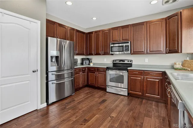 a kitchen with a refrigerator stove and wooden cabinets