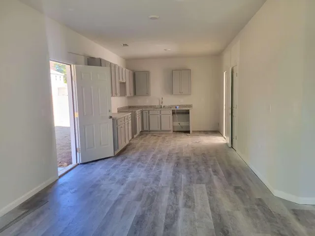 a view of a kitchen with wooden floor and electronic appliances