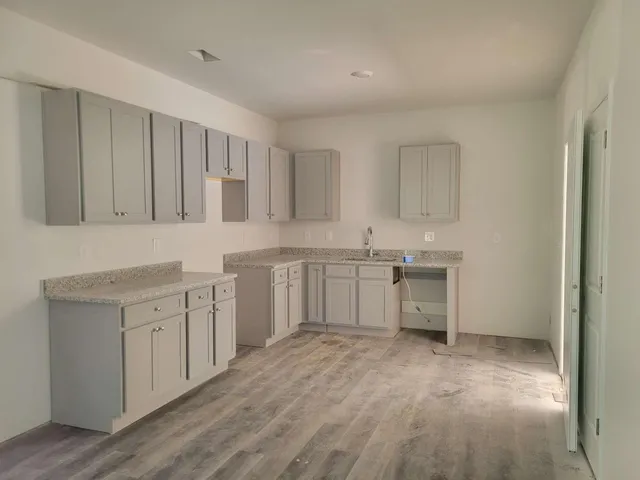 a kitchen with white cabinets and sink