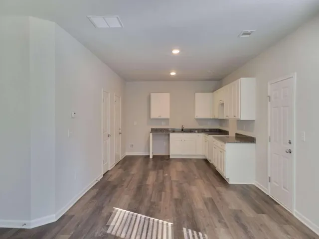 a view of a kitchen with wooden floor and electronic appliances