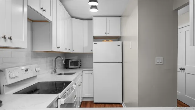 a kitchen with a refrigerator sink and cabinets
