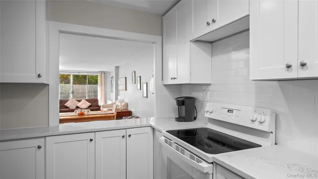 a kitchen with white cabinets and sink