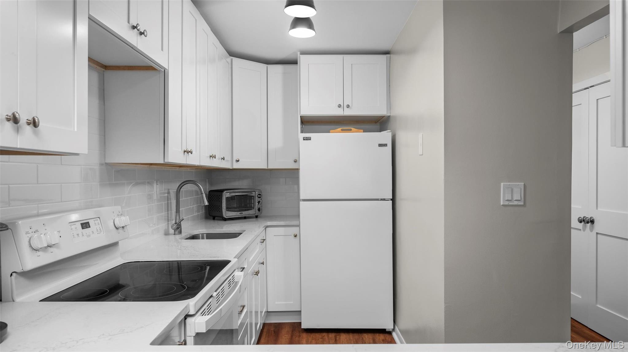 20 Old Mamaroneck Road, Unit 2D White Plains, NY 10605 - Photo 10 of 22 a kitchen with a refrigerator sink and cabinets