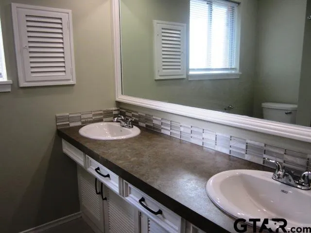 a bathroom with a granite countertop sink a mirror and a window