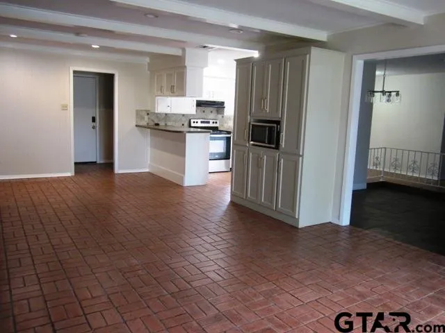 a view of kitchen with granite countertop cabinets and refrigerator