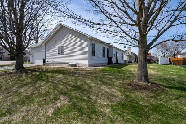 a view of a house with yard and tree in the background