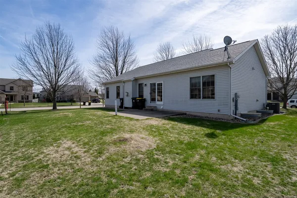 a backyard of a house with plants and large tree