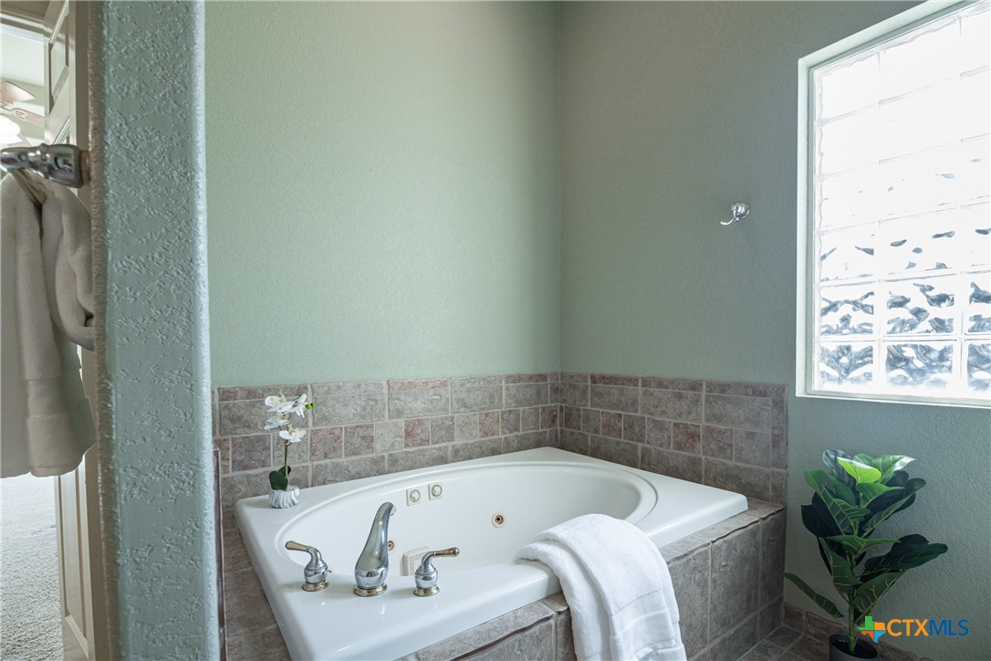 451 Winding View New Braunfels, TX 78132 - Photo 27 of 47 a bath tub sitting in a bathroom next to a window
