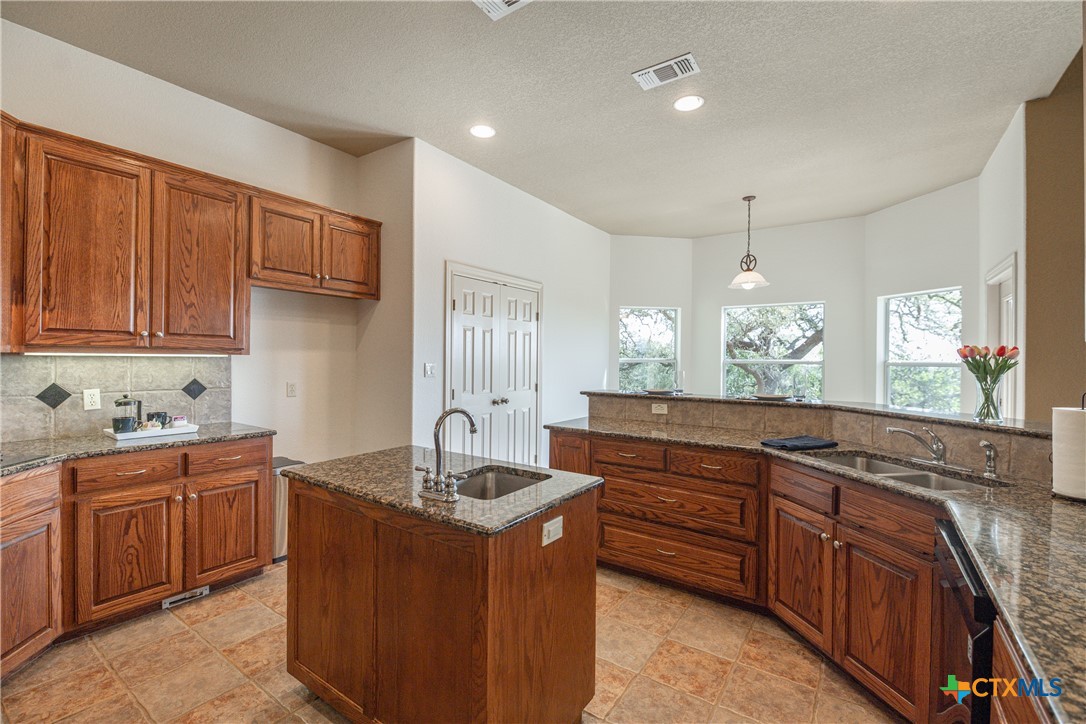 451 Winding View New Braunfels, TX 78132 - Photo 5 of 47 a kitchen with granite countertop a sink stove and cabinets