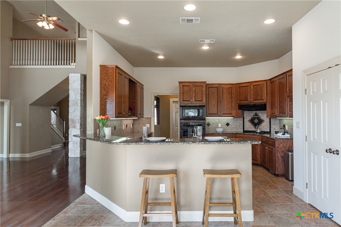 451 Winding View New Braunfels, TX 78132 - Photo 6 of 47 a kitchen with stainless steel appliances granite countertop a refrigerator a stove a sink a microwave and a refrigerator