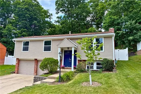 a view of a house with backyard and a tree