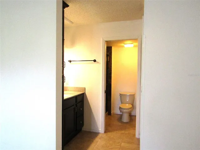 a bathroom with a granite countertop toilet and a sink