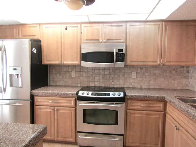 a kitchen with granite countertop a sink stove and refrigerator