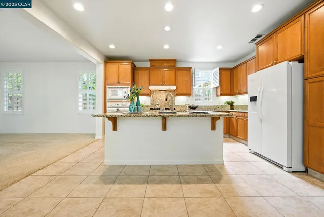 a kitchen with granite countertop cabinets stainless steel appliances and a counter space