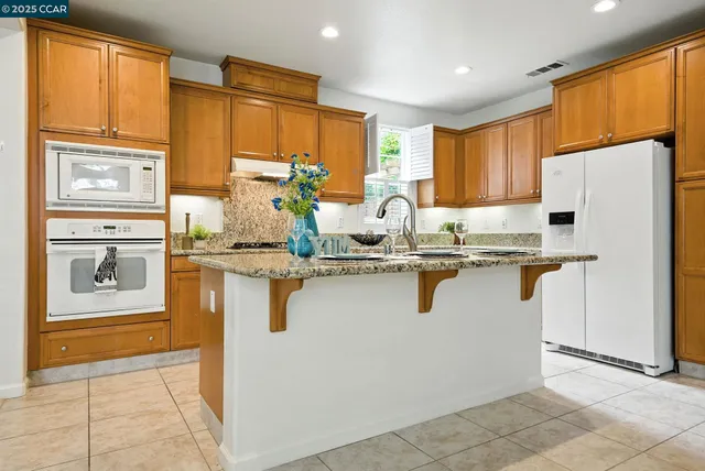 a kitchen with granite countertop a sink and cabinets