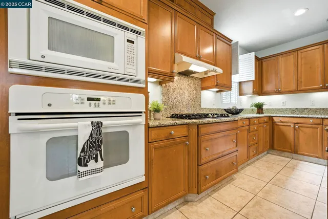 a kitchen with granite countertop a sink and cabinets