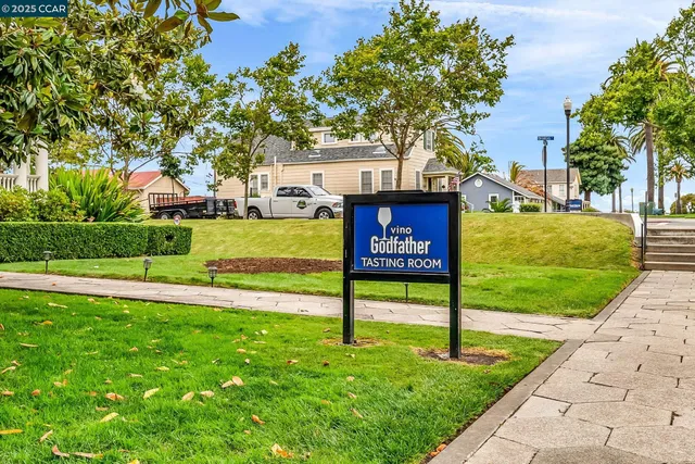 a sign board with a house in the background