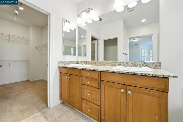 a bathroom with a granite countertop sink a toilet and a mirror