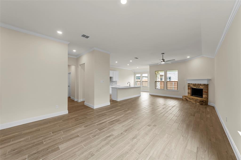 1508 Addison Lane Lancaster, TX 75134 - Photo 7 of 20 Spacious living area featuring wood-finish flooring, recessed lighting, and a brick fireplace with a white mantel