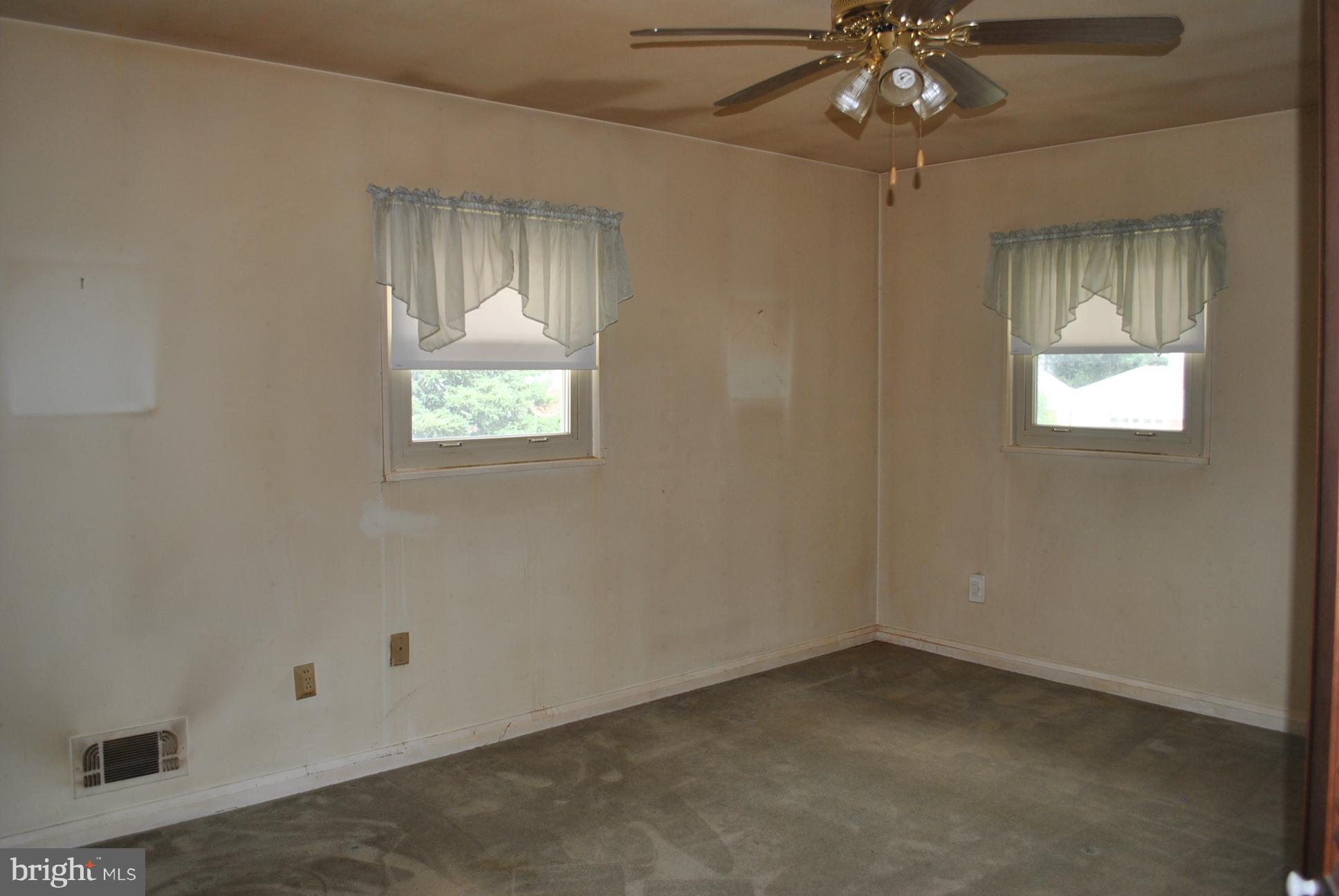 1027 Lakemont Road Baltimore, MD 21228 - Photo 9 of 14 an empty room with a chandelier fan and windows