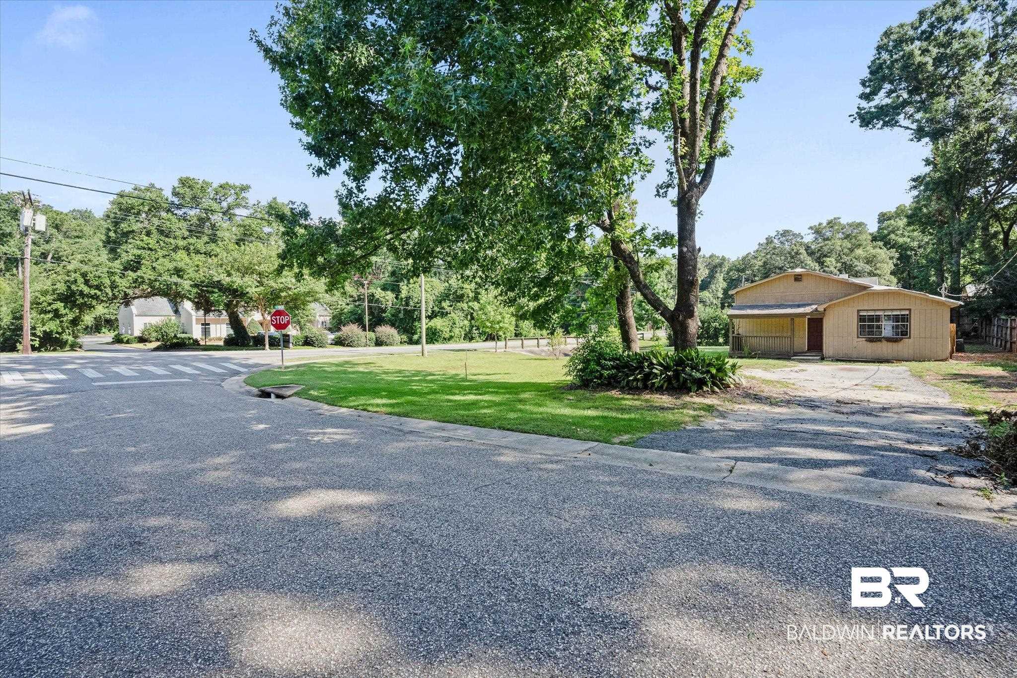 401 Frederick Avenue Fairhope, AL 36532 - Photo 18 of 36 Light yellow exterior with a covered porch and mature trees